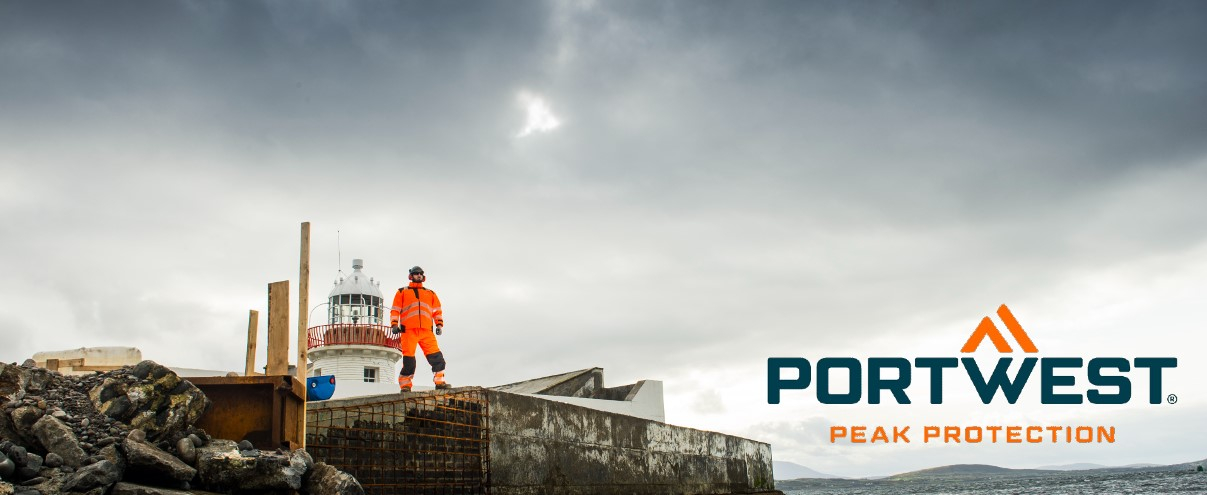 Um trabalhador que veste roupas laranja de alta visibilidade está num estaleiro de construção rochoso junto a um farol, com o logótipo da Portwest e o slogan 'Pick Protection' na foto.