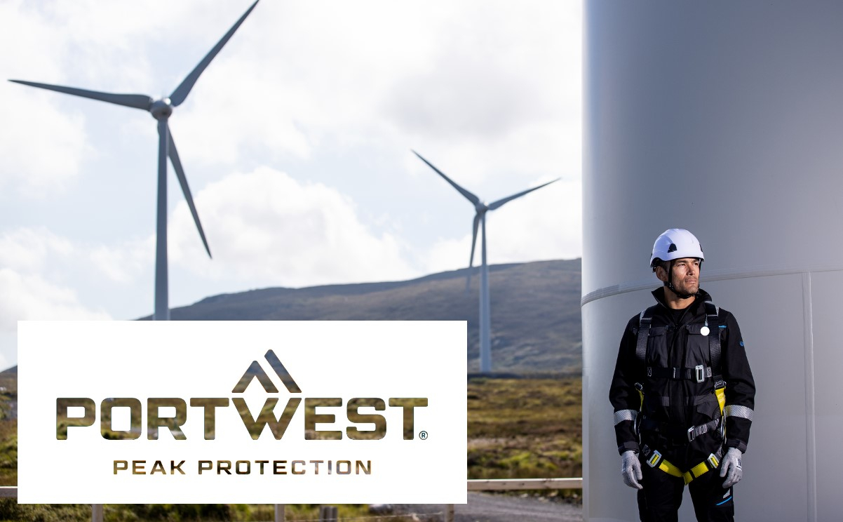 Um trabalhador que usa equipamento completo de proteção contra quedas está ao lado de uma turbina eólica. Mais turbinas eólicas podem ser vistas ao fundo. O logótipo da empresa Portwest com o slogan 'Peak Protection' é apresentado em primeiro plano. É fornecido um link que leva à nossa proteção contra quedas.