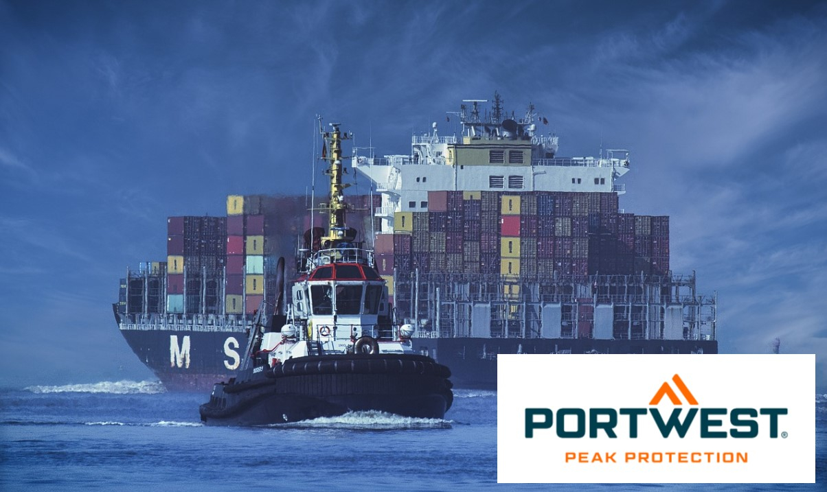 Um navio porta-contentores que transporta contentores coloridos é rebocado por águas calmas e azuis por um rebocador. O céu é de um azul profundo e o logótipo da Portwest é apresentado no canto inferior direito. É fornecido um link para a coleção de vestuário em condições de navegar.