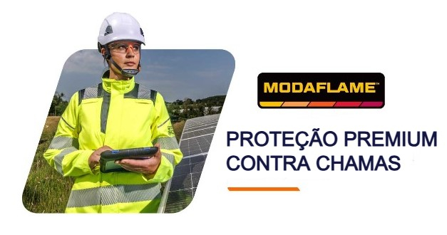 Mulher com roupa de proteção amarela de alta visibilidade e capacete branco a segurar um tablet e em frente a um prado e painéis solares. Ao lado está o logótipo Modaflame e o título Premium Inherent Flame Retardancy. É disponibilizado um link para a coleção Modaflame.